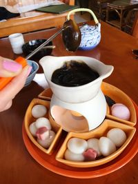 Close-up of hand holding tea cup on table