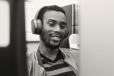 Smiling young man listening music on headphones