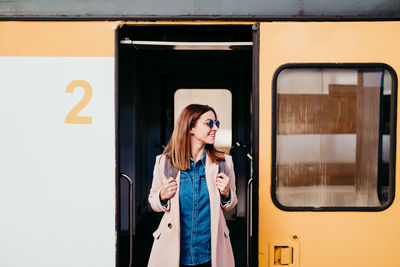 Full length of woman standing against train
