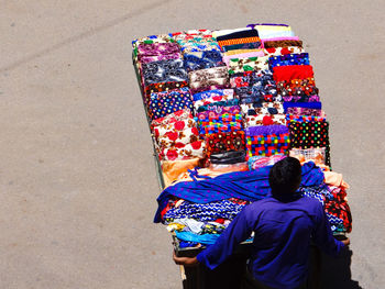 Rear view of man selling textile on street