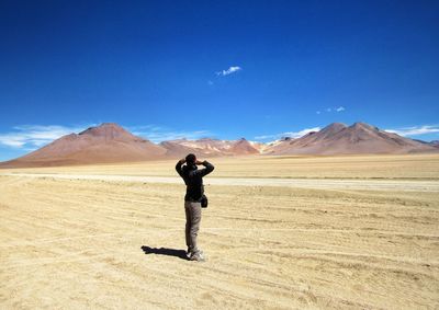 Full length of man standing on arid landscape