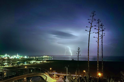 Illuminated cityscape against sky at night