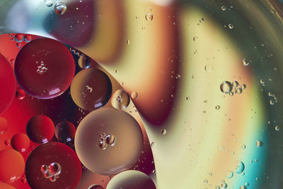 Top view oil bubbles drop on the water with colorful background, macro photography concept