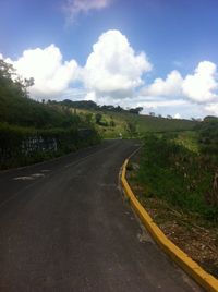 Road amidst trees against sky