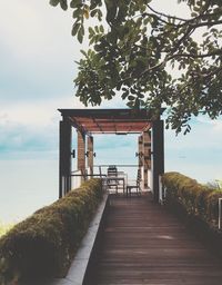 Walkway by sea against sky