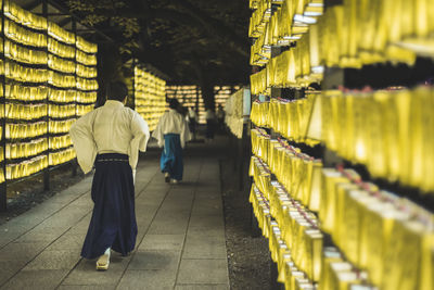 Rear view of people walking on narrow street