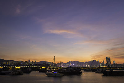 View of harbor and buildings against sky during sunset
