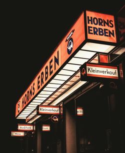 Low angle view of information sign at night