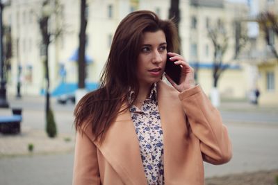 Portrait of beautiful young woman standing outdoors