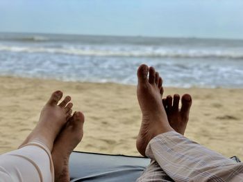Low section of people relaxing on beach