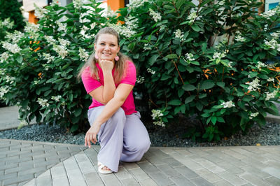 Full length of young woman standing on footpath