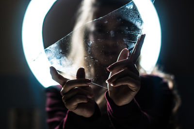 Woman holding glass over face