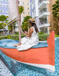 Rear view of woman sitting in boat