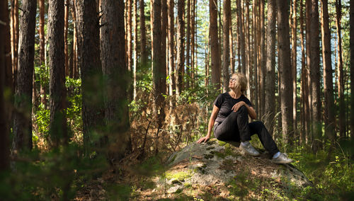 Full length of woman standing in forest