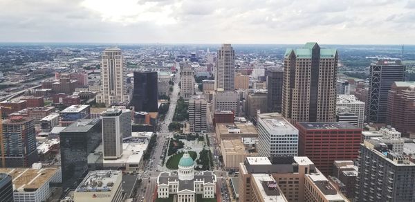 Aerial view of buildings in city against sky