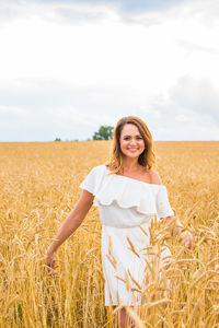 Portrait of smiling young woman standing on field