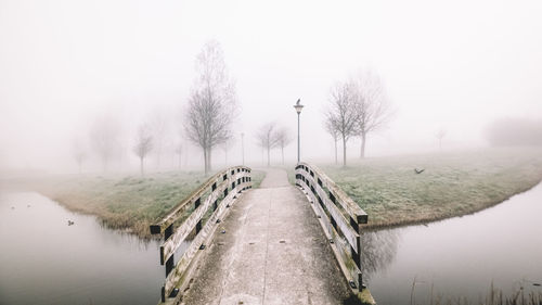 Scenic view of lake against sky during foggy weather