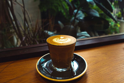 A cup of coffee latte top view with microfoam milk leaf shape foam.