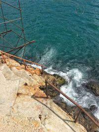 High angle view of sea waves splashing on rocks