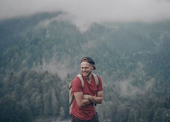 Happy young man standing on mountain