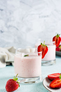 Milk smoothie with strawberries and mint in glasses on the table. healthy homemade food. 