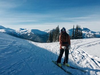 Full length of woman skiing on snow covered mountain