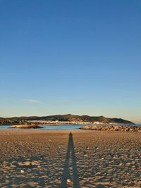 Scenic view of beach against clear blue sky