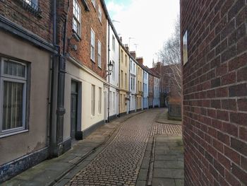 Empty alley amidst buildings in city