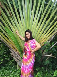 Portrait of smiling woman standing by plants