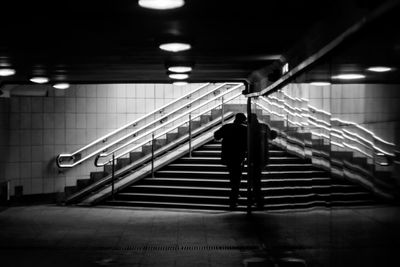 Rear view of man walking on escalator