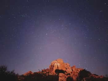 Low angle view of rock formation against sky at night