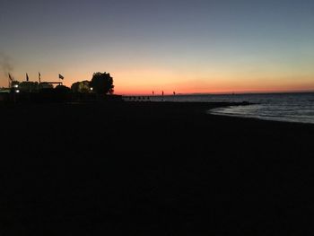 Scenic view of beach against clear sky during sunset