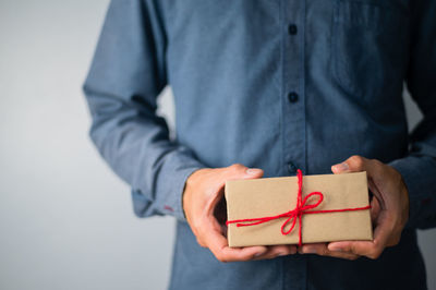 Midsection of man holding paper in box