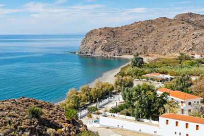 High angle view of townscape by sea against sky