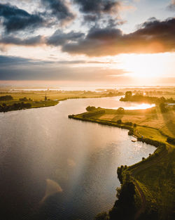 Scenic view of river against sky during sunrise