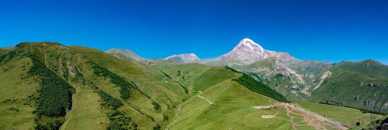Scenic view of mountains against clear blue sky