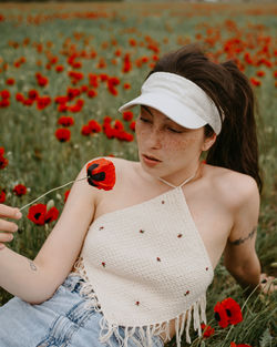 Woman looking at flower in field