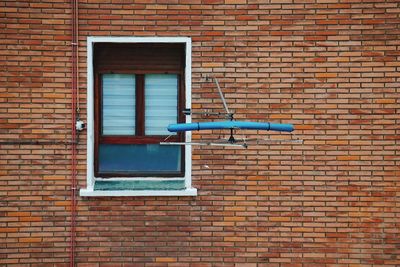 Low angle view of window on brick wall