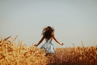 Woman standing on field against clear sky