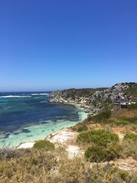 Scenic view of beach against clear blue sky