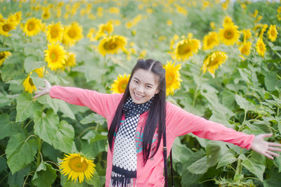 Portrait of woman standing on sunflower field