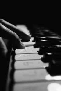 Close-up of hand playing piano