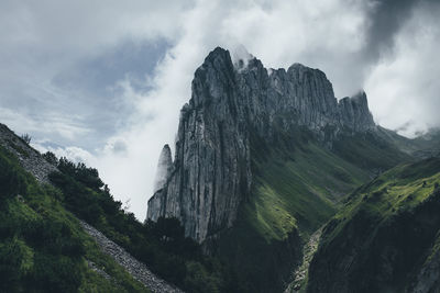 Low angle view of mountain against cloudy sky