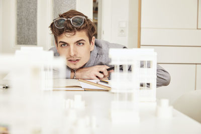 Portrait of young man sitting on table