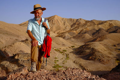 Rear view of man standing on rock formations