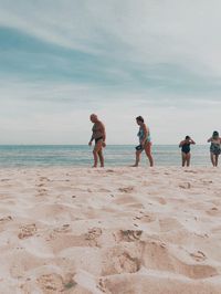 People on beach against sky