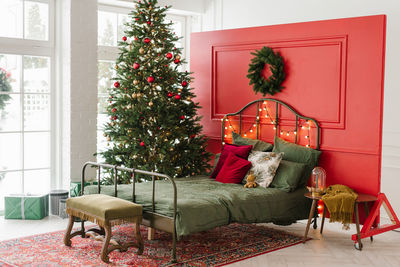 Classic room interior with a christmas tree and traditional red and green decorations. 