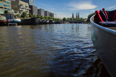 Boats in river with buildings in background