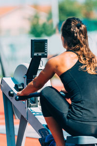 Woman exercising in gym during sunny day