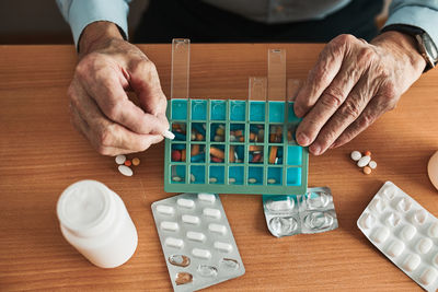 Senior man organizing his medication into pill dispenser. senior man taking pills from box